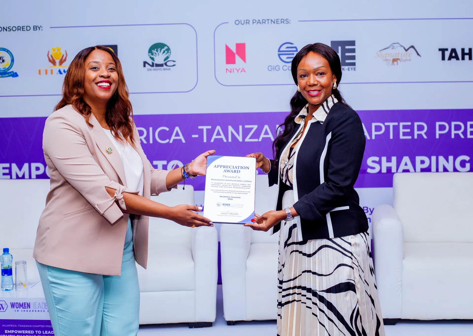 Rosalynn Mworia receiving the Appreciation Award from Lorna Mbwette at WLIAfrica Tanzania
